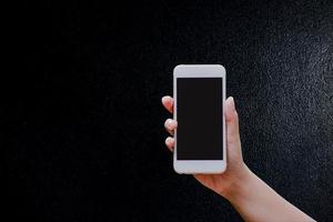 mani e telefoni schermo nero, sfondo nero, concetto di tecnologia e per fare affari online. foto