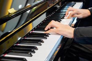 chiuda sulla mano del musicista che suona il pianoforte foto