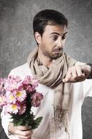 uomo innamorato di un mazzo di fiori che guarda con preoccupazione. immagine verticale. foto