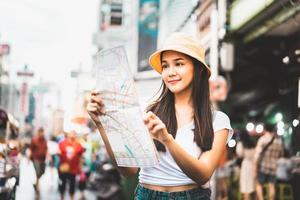 donna asiatica che cerca con la mappa a chinatown foto