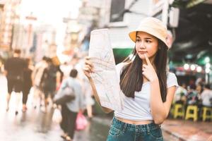 donna asiatica che cerca con la mappa a chinatown foto