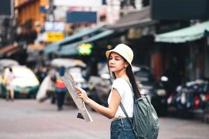 il viaggiatore asiatico del giovane adulto esplora la mappa di ricerca durante la visita della città. al punto di riferimento Khaosan foto