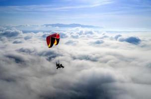 il parapendio vola liberamente sopra le nuvole. concetto di sfida e libertà. foto