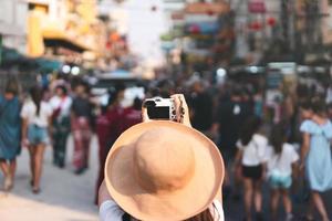 il viaggiatore della giovane donna asiatica scatta una foto con la fotocamera a khaosan street road.