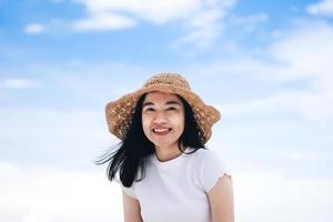 il ritratto della donna asiatica adulta di sorriso felice si rilassa nella natura con il cielo all'aperto il giorno foto