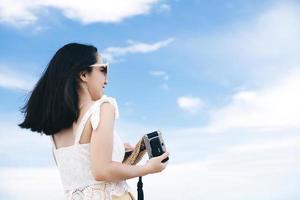 la giovane donna asiatica adulta si rilassa nella natura con lo sfondo del cielo blu. foto