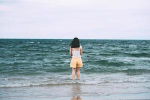 ritratto di vista posteriore giovane donna asiatica adulta rilassarsi in spiaggia nei giorni. foto