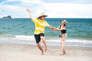 le coppie divertenti asiatiche dei giovani adulti si rilassano viaggiare all'aperto al mare durante le vacanze estive. foto