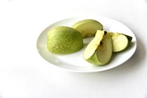fette di mela verde su un piatto bianco foto
