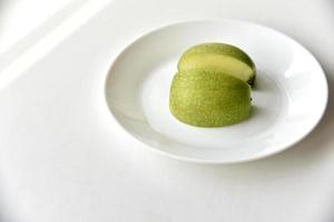 fette di mela verde su un piatto bianco foto