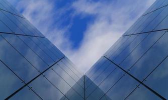 dalla vista di un edificio pieno di specchi si vede il cielo e le nuvole bianche. riflesso speculare dall'edificio. rendering 3D foto