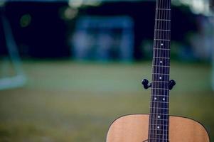 la chitarra è collocata in un prato verde. concetto musicale e c'è uno spazio di copia. foto