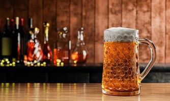 birra alla spina o artigianale in vetro alto trasparente. con vapore freddo, schiuma di birra bianca posta su un pavimento di legno, dietro lo sfondo c'è una bottiglia di vino, whisky, brandy al ristorante o al bar. rendering 3D
