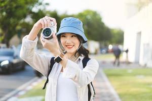 attraente giovane donna asiatica adulta viaggiatore utilizzando la fotocamera per il viaggio fotografico. foto