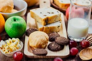 colazione con biscotti, pane, frutta fresca per un'alimentazione sana e latte foto