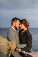 servizio fotografico di matrimonio di una coppia in riva al mare. abito da sposa blu sulla sposa. foto