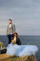 servizio fotografico di matrimonio di una coppia in riva al mare. abito da sposa blu sulla sposa. foto