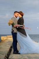 servizio fotografico di matrimonio di una coppia in riva al mare. abito da sposa blu sulla sposa. foto