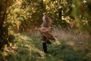 bella donna elegante in piedi in un parco in autunno foto