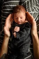 un bambino appena nato sta guardando la finestra nella sua culla. un bambino nato a 8 mesi di gestazione. c'è un vestito lavorato a maglia sul ragazzo. foto