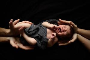 un bambino appena nato sta guardando la finestra nella sua culla. un bambino nato a 8 mesi di gestazione. c'è un vestito lavorato a maglia sul ragazzo. foto