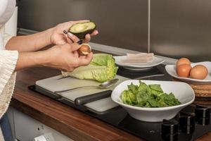 raccolto casalinga che cucina insalata per pranzo a casa foto