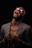 un afroamericano nero sta cantando emotivamente in un microfono. ritratto in studio ravvicinato. foto
