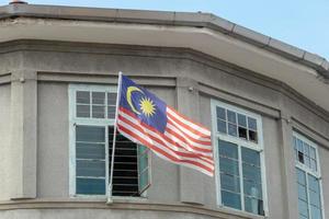 la bandiera della Malesia è appesa al vecchio edificio di georgetown. foto