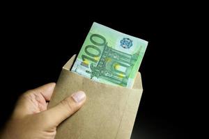 mano maschio che tiene busta di stipendio banconote di denaro in euro. foto