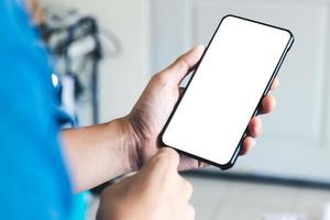 mockup copia spazio telefono, mano d'uomo che tiene smartphone con schermo bianco vuoto per la tua pubblicità e messaggio o contenuto informativo, cellulare sulla scrivania al bar. foto