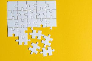 puzzle posizionati su un concetto creativo di sfondo giallo con spazio di copia foto