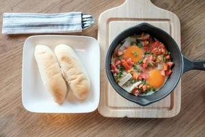 uova fritte in padella con carne di maiale e tutte le verdure su tavola di legno. è in stile vietnamita e popolare nel sud-est asiatico. foto