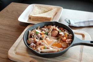 uova fritte in padella con carne di maiale e tutte le verdure su tavola di legno. è in stile vietnamita e popolare nel sud-est asiatico. foto