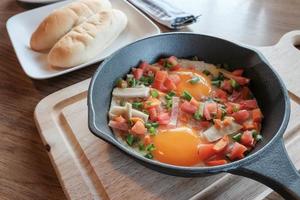 uova fritte in padella con carne di maiale e tutte le verdure su tavola di legno. è in stile vietnamita e popolare nel sud-est asiatico. foto