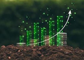 mucchio di monete con grafico a barre digitale verde concetto di analisi delle tendenze future delle attività finanziarie per iniziare a risparmiare o investire. foto