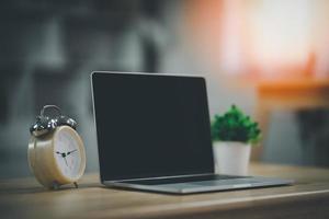 spazio di lavoro con laptop e orologio sul tavolo nello spazio di co-working. spazio di lavoro concettuale, spazio vuoto scrivania bianca con sullo schermo del computer portatile. foto