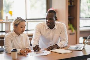 due colleghi etnici di deferenza che lavorano insieme in moderni partner commerciali cafe.black che discutono di un nuovo progetto di avvio. foto