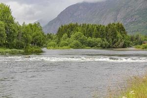 che scorre bellissimo fiume turchese lago con pietre a Ulsak, Norvegia. foto