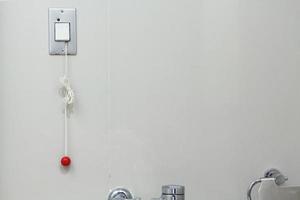 l'infermiera chiama in un bagno per il paziente tirare la corda o premere il pulsante per chiedere aiuto. pulsante di emergenza o pulsante per consentire ai pazienti di chiedere aiuto agli infermieri. foto