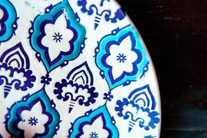 piatto con motivo orientale blu e bianco su fondo in legno foto