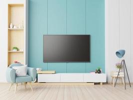 tv sul mobile in soggiorno moderno con poltrona su sfondo blu muro.