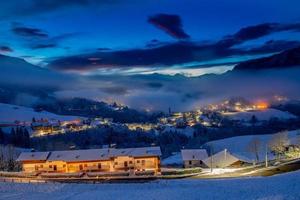 paesino di montagna innevato al tramonto foto