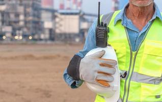 ingegneri senior che indossano guanti e caschi per lavorare, anziani asiatici in abiti da lavoro di sicurezza. foto