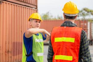 squadra di ingegnere e caposquadra che controlla la scatola dei contenitori dal carico con sfondo sfocato, concetto di lavoro di squadra foto