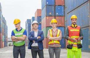 ingegnere della felicità e squadra di lavoratori in piedi al carico di container, concetto di lavoro di squadra di successo foto