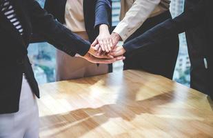 concetto di successo e di lavoro di squadra, la squadra di uomini d'affari che si unisce alle mani dopo l'incontro in un ufficio moderno foto