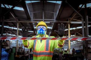 l'industria dell'ingegnere che indossa l'uniforme di sicurezza, i guanti neri, la maschera antigas si sente soffocare quando si controlla il serbatoio chimico nel lavoro di fabbrica dell'industria. foto