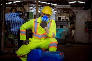 l'industria dell'ingegnere che indossa l'uniforme di sicurezza, i guanti neri, la maschera antigas si sente soffocare quando si controlla il serbatoio chimico nel lavoro di fabbrica dell'industria. foto