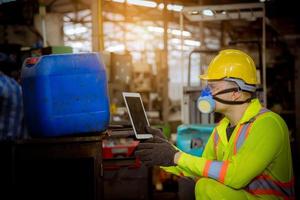 l'industria dell'ingegnere che indossa l'uniforme di sicurezza, i guanti neri, la maschera antigas si sente soffocare quando si controlla il serbatoio chimico nel lavoro di fabbrica dell'industria. foto