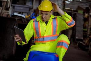 l'industria dell'ingegnere che indossa l'uniforme di sicurezza, i guanti neri, la maschera antigas si sente soffocare quando si controlla il serbatoio chimico nel lavoro di fabbrica dell'industria. foto